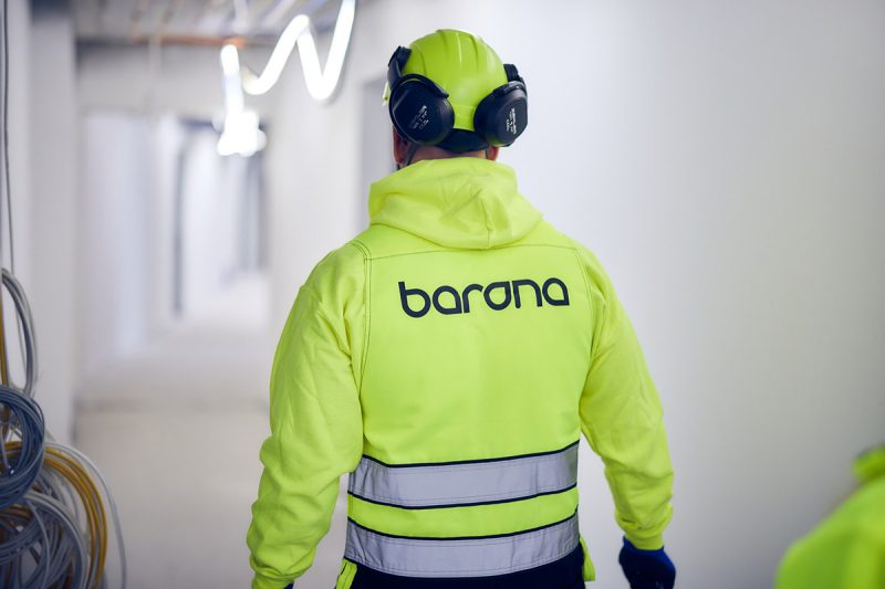 Bilde av en mann på en byggeplass med Barona-klær som går bort fra kameraet.